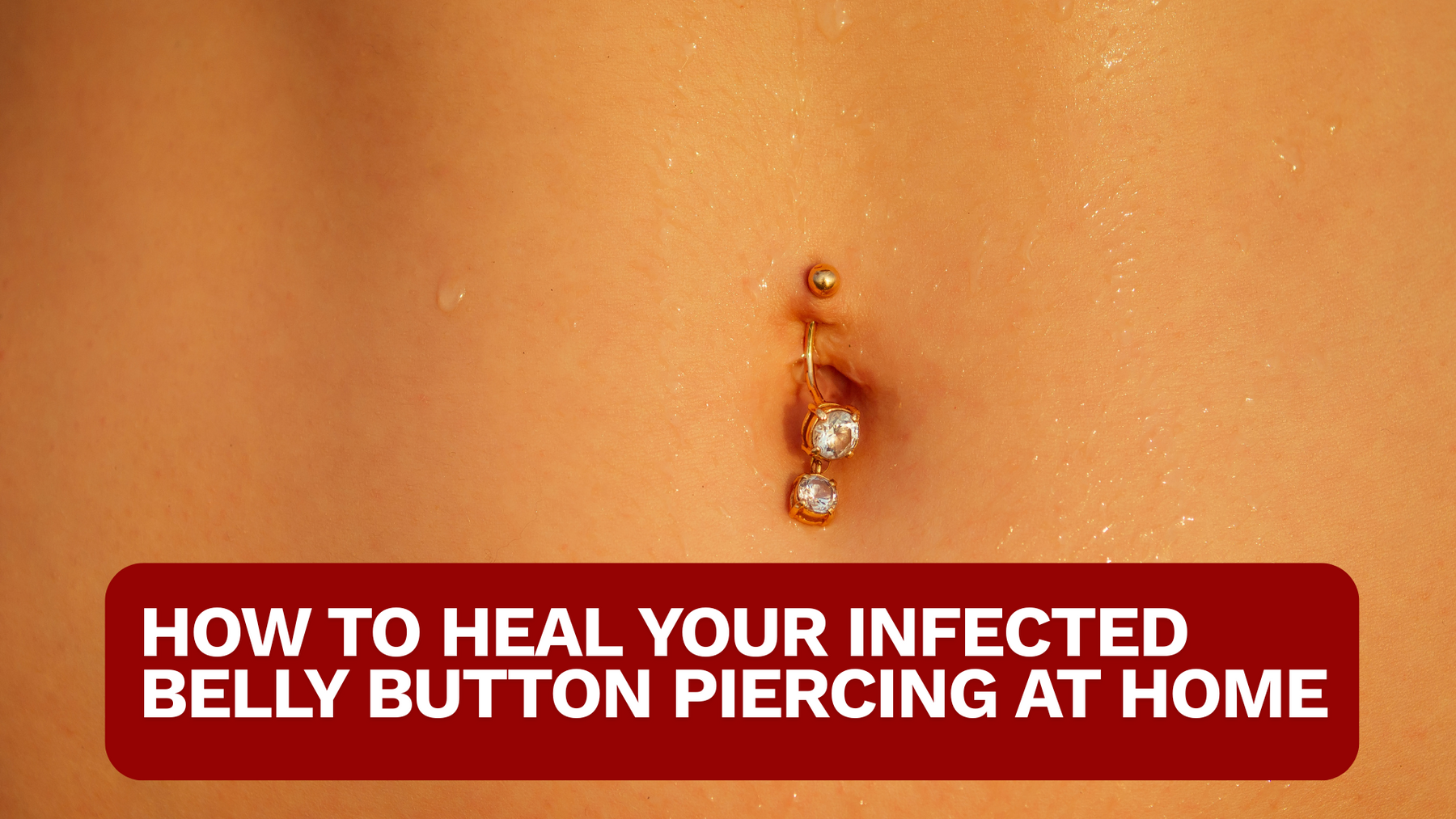 CLOSE UP OF A BELLY WITH DANGLING GOLD BELLY PIERCING