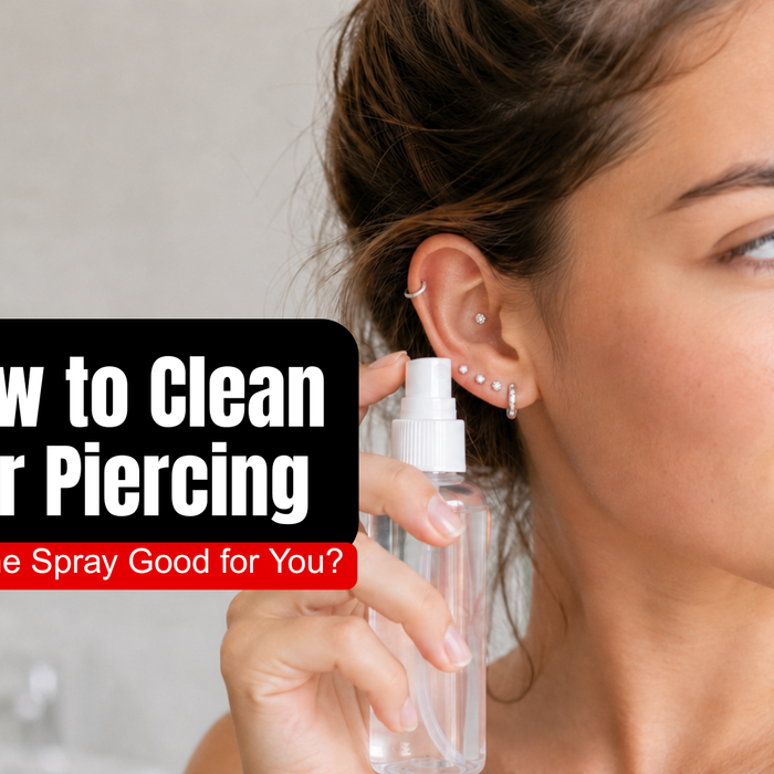 Young woman using sterile saline spray to clean a newly pierced ear with a curated silver ear stack.