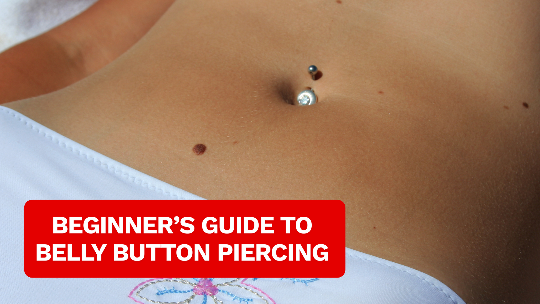 close up of a belly with belly piercing jewellery