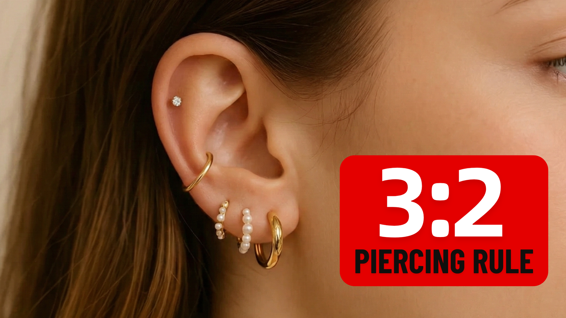 Close-up of a curated ear stack following the 3-2 piercing rule with gold hoops and dainty studs.