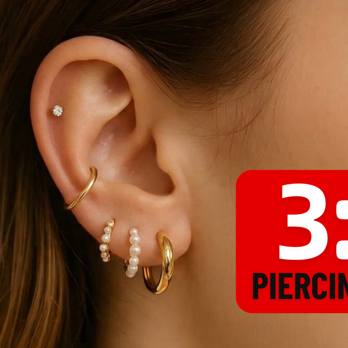 Close-up of a curated ear stack following the 3-2 piercing rule with gold hoops and dainty studs.