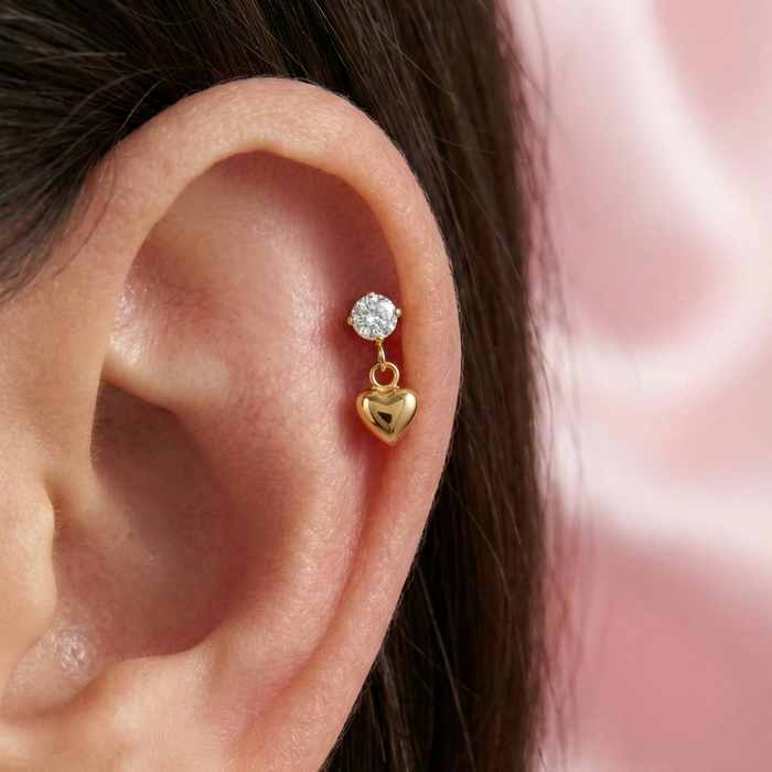 Gold DANGLING HEART CZ stud worn on upper ear cartilage, showcasing its elegant fit and sparkle for helix or tragus piercings.